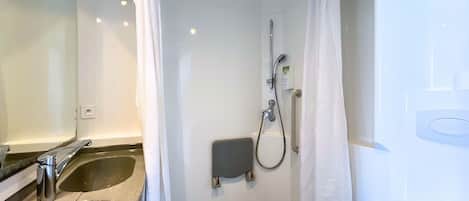 A bathroom with a sink, shower, and toilet.