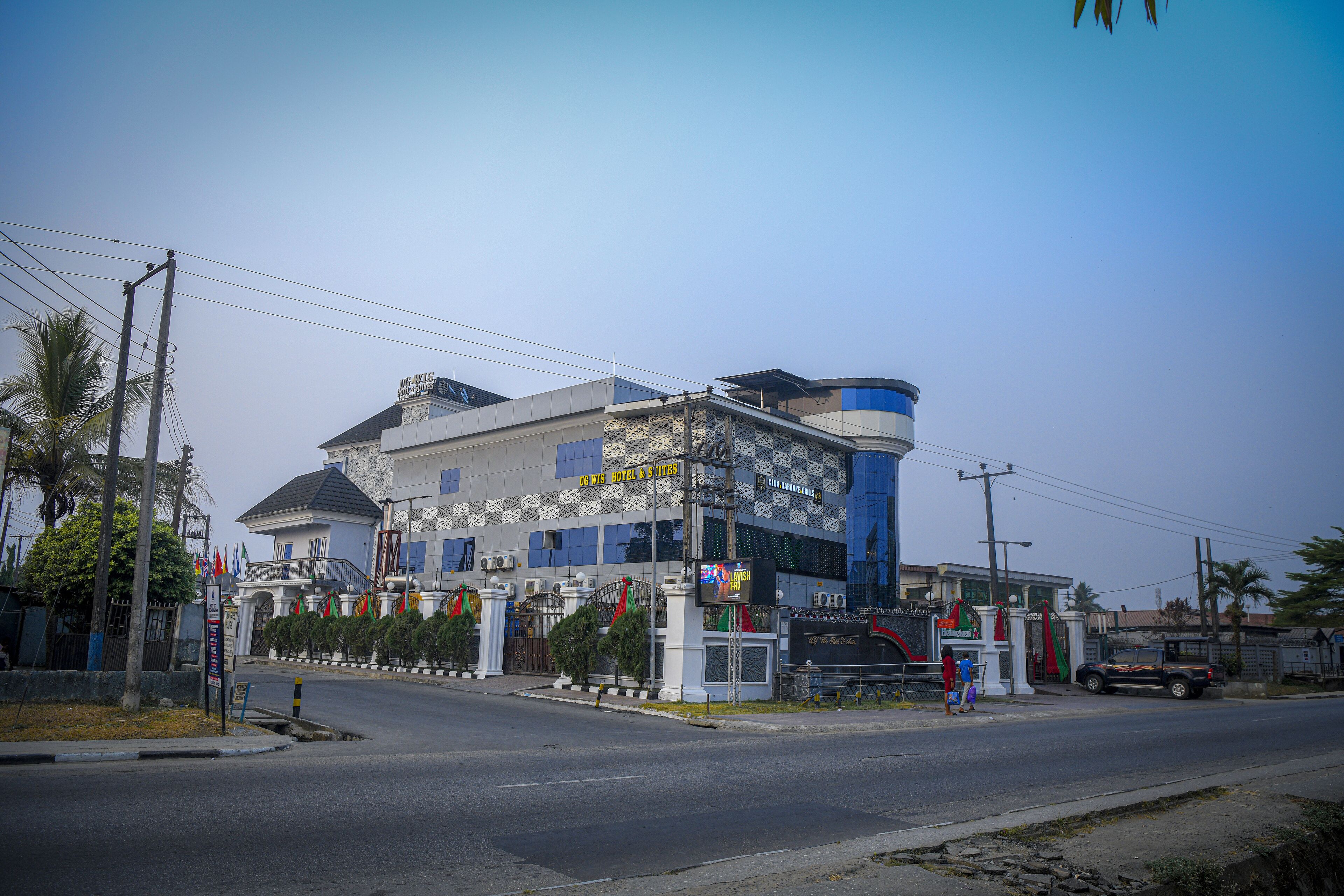 Ein modernes Hotel mit markanter Architektur, das einen gewölbten blauen Turm und ein befestigtes Eingangsportal zeigt.