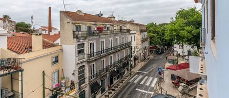 Une vue de rue avec des immeubles, une ligne de tramway et des voitures garées.
