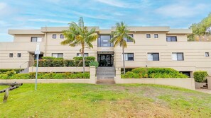 A modern building with a flat facade, multiple windows, and a central entrance. - Paradiso, 4,4 Laman St - Unit with aircon, wi-fi, pool and in the heart of town, water views (Nelson Bay)