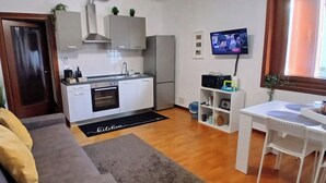 A compact living space with a kitchenette, a dining area, and a sofa. - Mi casa es tu casa PN.Free Parking. Great location. (Pordenone)