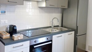 A modern kitchen with stainless steel appliances, a double sink, and white cabinetry. - Mi casa es tu casa PN.Free Parking. Great location. (Pordenone)