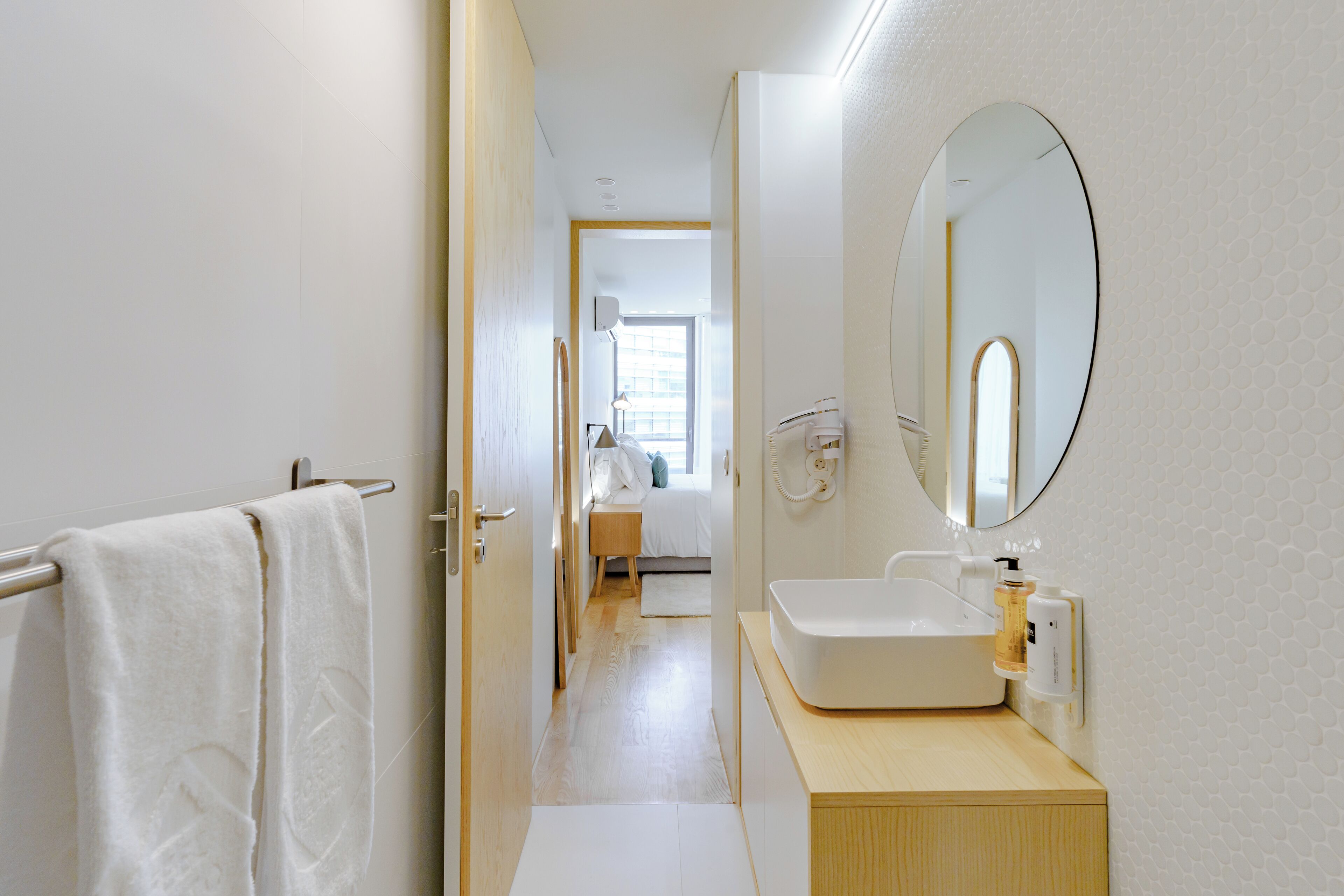 Un bagno moderno con uno specchio grande, un lavandino e un porta asciugamani.