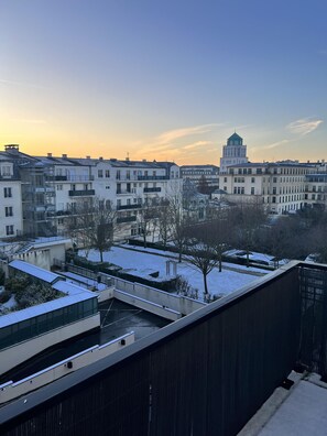 A residential area with snow-covered ground and buildings with balconies.