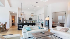 A spacious living room with a white sofa, a wooden coffee table, and a patterned rug. - Luxury Waterfront 4BR Home w/ Pool & Hot Tub (Cape Coral)