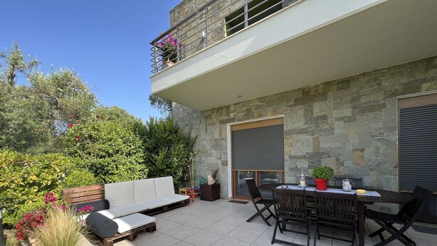 An outdoor patio with a dining table, chairs, a sofa, and a potted plant. - Angelos elegant summer house  (Kassandra)