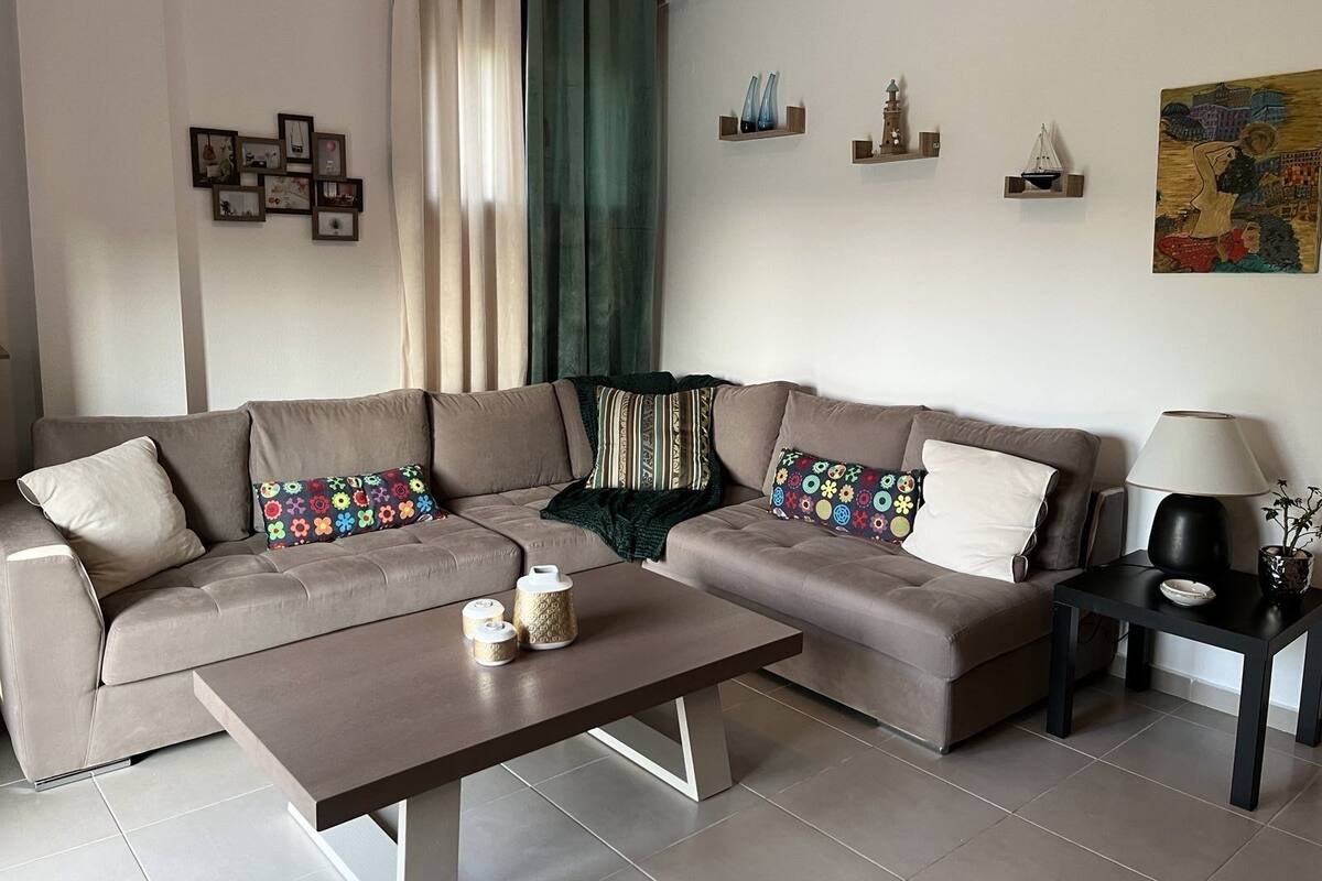 A modern living room with a sectional sofa, a coffee table, and decorative items.