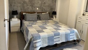 A bedroom with a bed, two nightstands, a dresser, and a mirror. - Angelos elegant summer house  (Kassandra)