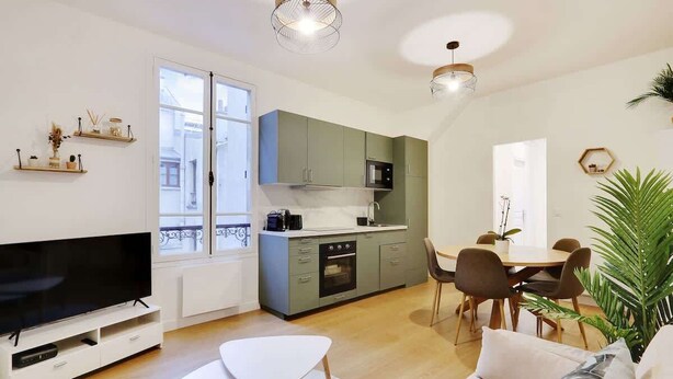 Un appartement moderne comprenant une cuisine, un coin repas et un salon.
