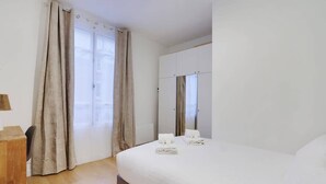 Une chambre d’hôtel avec un lit, un bureau et une armoire.