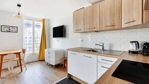 Een moderne keuken met houten kastjes, een zwart aanrecht en een inbouwgootsteen.