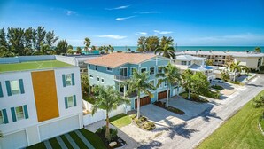 Un barrio residencial costero con casas modernas, vista despejada al océano y césped bien cuidado.