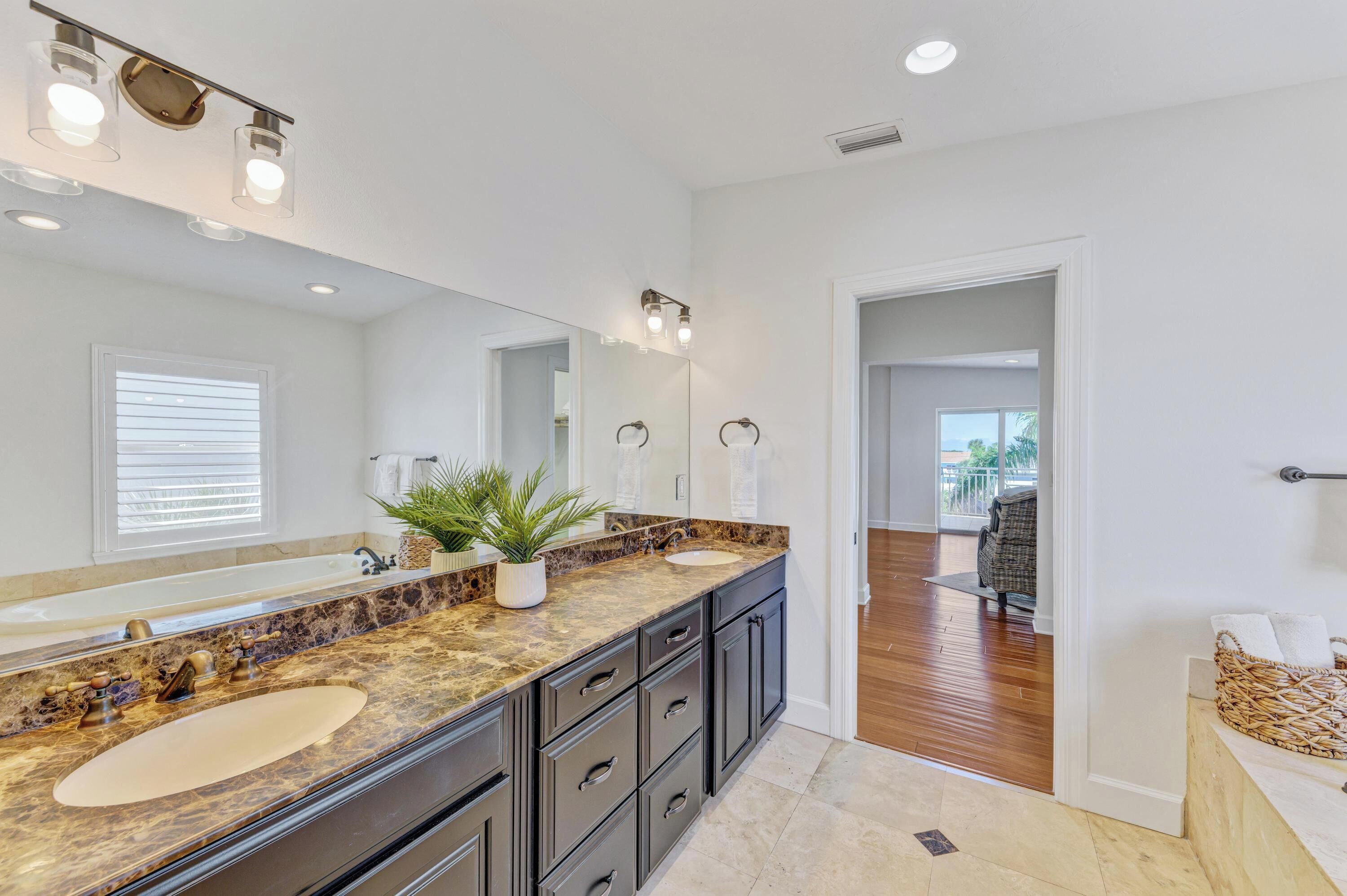 A modern bathroom with a large vanity, double sinks, and a large mirror.