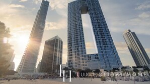 Un immeuble moderne de grande hauteur, doté d’une architecture originale et caractérisé par une découpe verticale bien visible.