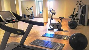Une salle de sport équipée de machines de cardio, d’un rameur et d’un vélo d’appartement.