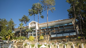 Un hotel de varios pisos con fachada de piedra, múltiples balcones y cielo despejado.