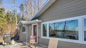 A deck with outdoor seating and a grill, overlooking a forested area. - Hines Vacation Rental w/ Grill: Walk to Lake! (Hines)