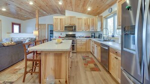 A modern kitchen with wooden cabinets, stainless steel appliances, and a central island. - Hines Vacation Rental w/ Grill: Walk to Lake! (Hines)