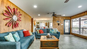 A living room with two blue sofas, a wooden coffee table, and a decorative wall piece. - Private Dock, Lanai: Bayou Retreat in Barataria! (Barataria)