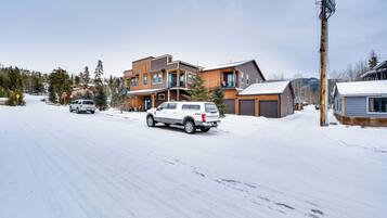 Una calle residencial con casas, una señal de parada y una carretera cubierta de nieve.
