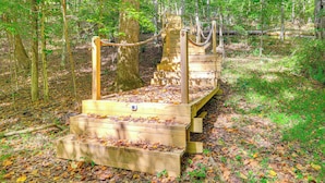 A wooden staircase leading up to a platform in a forested area.