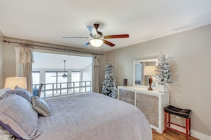 A bedroom with a bed, a ceiling fan, a dresser, a mirror, and two Christmas trees. - Tennessee River Vacation Rental w/ Deck + View! (Counce)