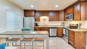 A kitchen with wooden cabinets, stainless steel appliances, and a granite countertop. - Modern Lehi Apartment: 2 Mi to Thanksgiving Point (Lehi)