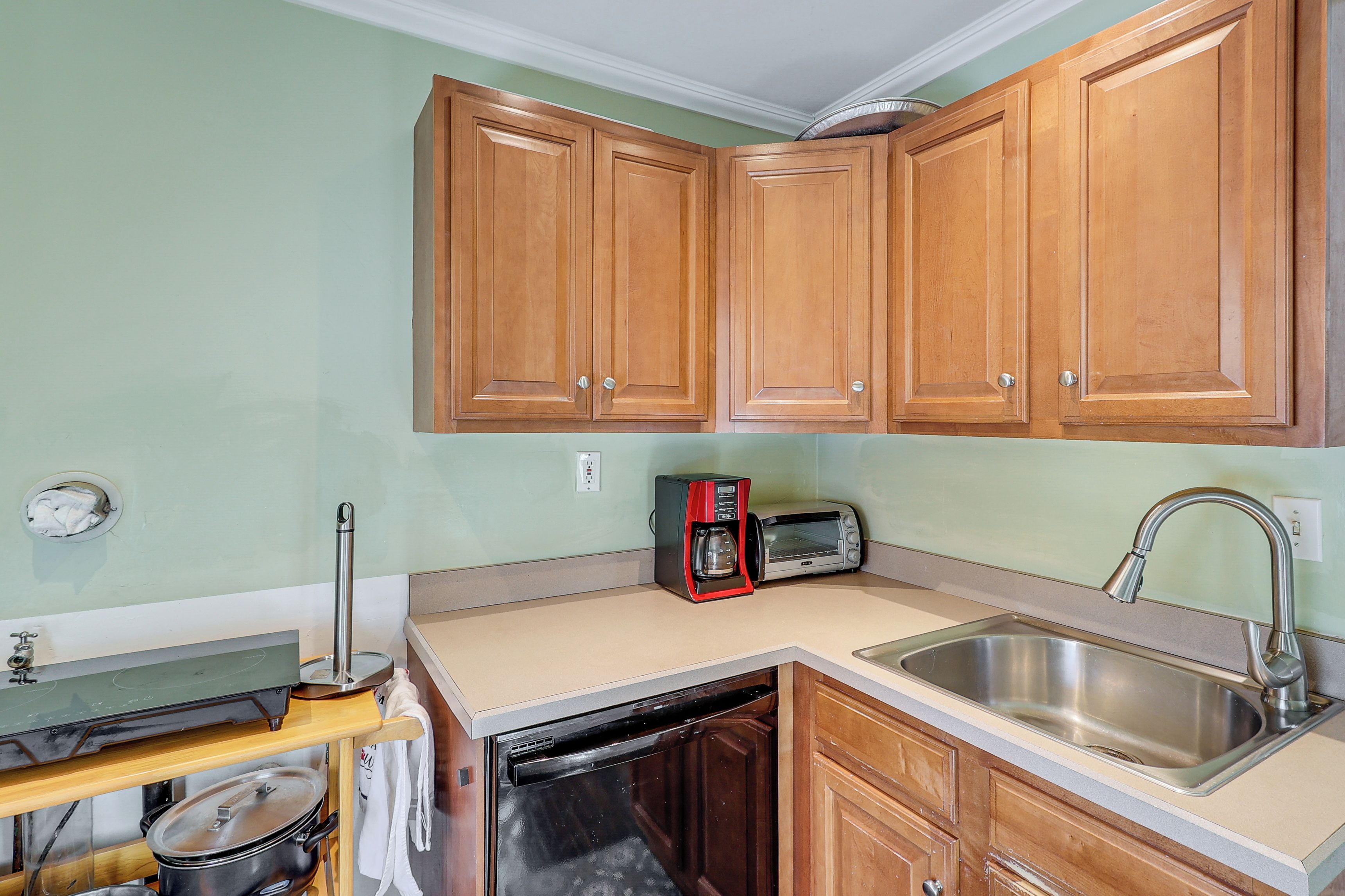 A kitchen with wooden cabinets, a microwave, a sink, and a dishwasher.