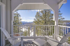 A covered porch with white railings and two white Adirondack chairs. - Pagosa Springs Family Retreat w/ Game Room & Views (Pagosa Springs)