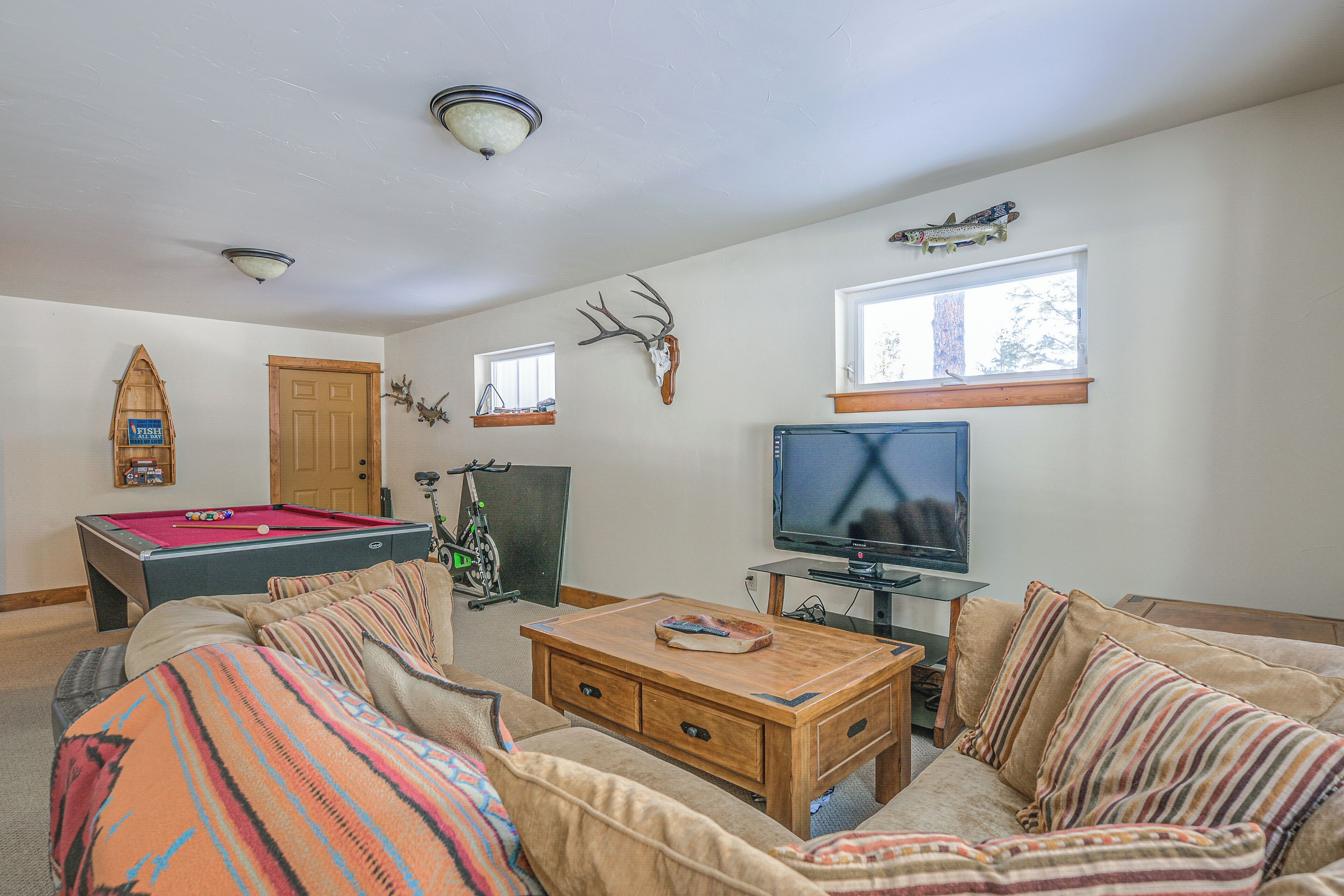 A living room with a pool table, a television, a sofa, and a coffee table.