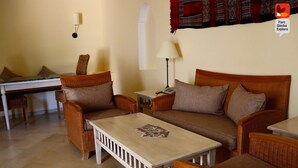 A cozy living room with wicker furniture, a small table, and a lamp. - Parc Djerba Explore Residence (Aghir)