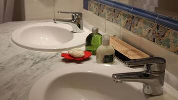 A bathroom with two sinks, a mirror, and a decorative tile backsplash.