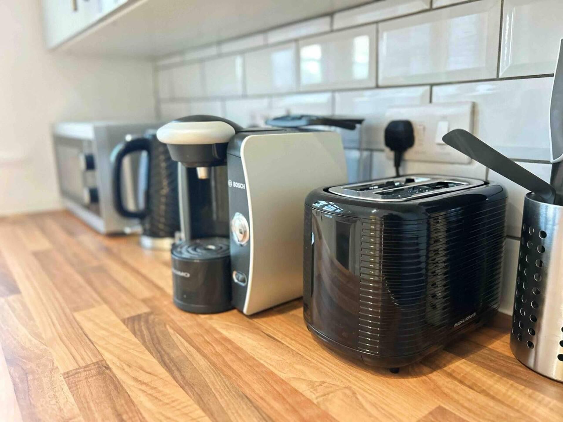 Eine Küche mit Toaster, Kaffeemaschine und Mixer auf einer Holzausziehtafel.