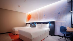 Una habitación de hotel moderna con una cama grande, un escritorio y una silla.