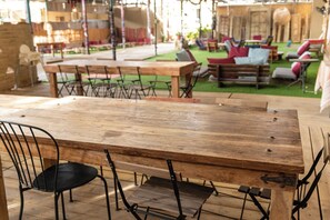 A wooden table with metal chairs in an outdoor setting.