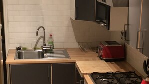 A compact kitchen with a sink, stove, and toaster. - nifty two bed urban flat near leafy park and city (Gateshead)
