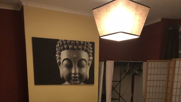 A bedroom with a bed, a Buddha painting on the wall, a hanging light fixture, and a view of a traditional Japanese room divider. - nifty two bed urban flat near leafy park and city (Gateshead)