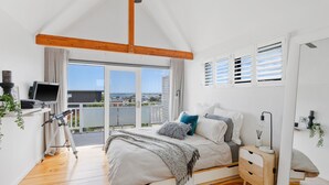 Un dormitorio con cama, mesita de noche y vistas al mar.