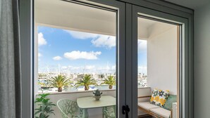 A balcony with a view of a marina, a table, chairs, and potted plants. - Captain's Quarters at Lagos Marina (Lagos)
