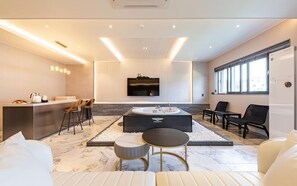A modern living room with a central seating area, a built-in TV, and a large window. - Gyeongju H Avenue Hotel Bulguksa (Gyeongju)