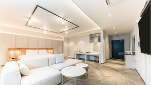 A modern hotel room with a large bed, a desk, and a kitchenette. - Gyeongju H Avenue Hotel Bulguksa (Gyeongju)