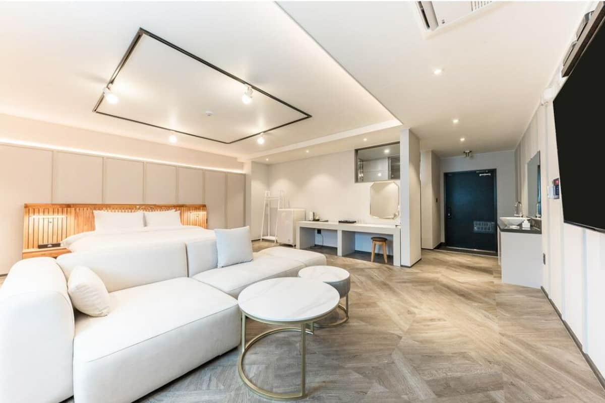 Une chambre d’hôtel moderne équipée d’un grand lit, d’un bureau et d’une kitchenette.