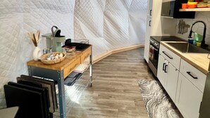Une cuisine de taille réduite, dotée d’un plan de travail en bois, d’un évier et d’une cuisinière.