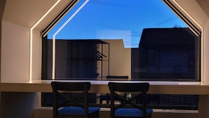 A room with a large window, a desk, and two chairs. - b&b d'Ereplatse (Zuienkerke)