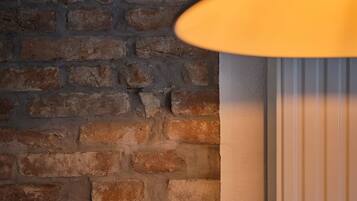 A brick wall with a textured surface and a white panel with vertical lines.