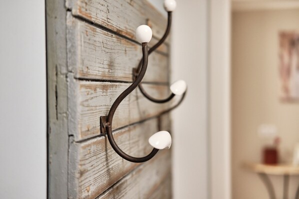 A wall-mounted metal hook with three spherical bulbs.