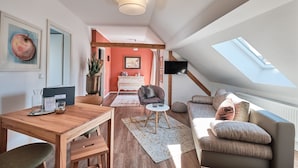 Un moderno apartamento tipo loft con comedor, sala de estar, televisor y tragaluz.