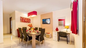A modern dining area with a wooden table, black chairs, and a red pendant light. - Blue 2: Two-Bedroom Apartment in St. Julian's (Swieqi)