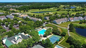 A residential area with houses, a swimming pool, tennis courts, and a golf course. - Comfortable 4 bedroom Townhome in Excellent Location, Bear Trap Dunes Community! Community Pool, Shuttle Service, WIFI, Golf, and more! (Ocean View)
