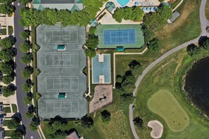 An aerial view of a sports complex with multiple tennis courts, a golf course, and a swimming pool. - Comfortable 4 bedroom Townhome in Excellent Location, Bear Trap Dunes Community! Community Pool, Shuttle Service, WIFI, Golf, and more! (Ocean View)